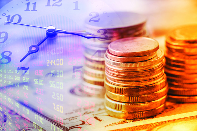 Closeup view : Stack of coins and clock hands. A concept / idea of time value of money. Money at present time is worth more than the same amount in the future due to its potential earning capacity.