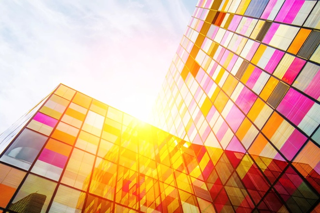 a colorful glass building in the morning from below