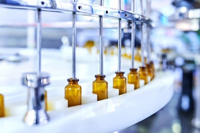 image of assembly line filling up glass bottles in a lab