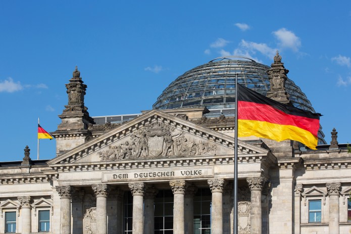 Reichstag building - the famous inscription on the architrave on the west portal of the Reichstag building in Berlin: "Dem Deutschen Volke" with german flag (Germany)