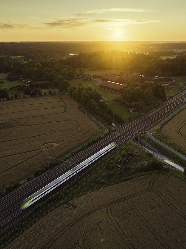 A train in motion on a railway through a rural landscape at sunset