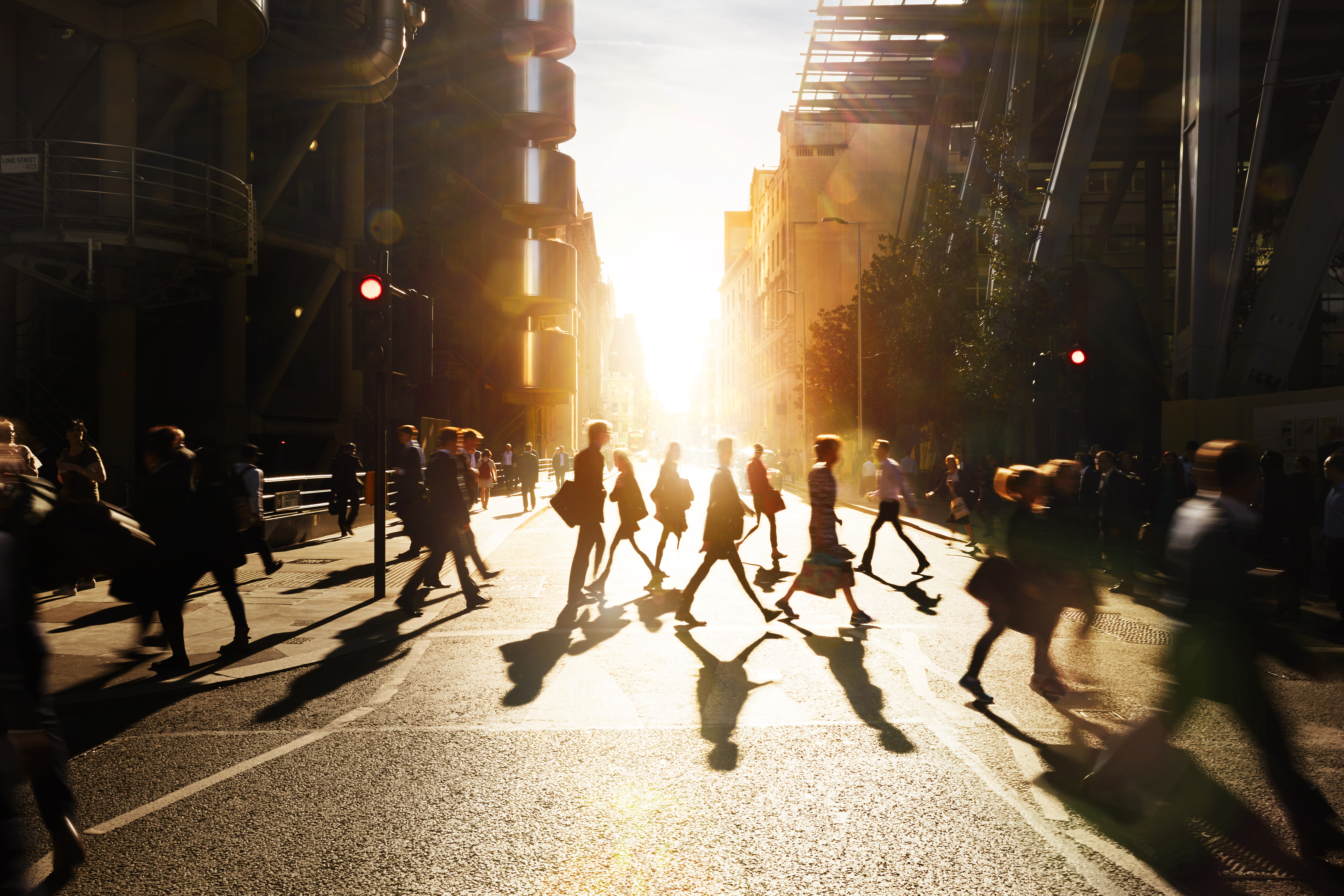 Business people walking through a city at dawn.