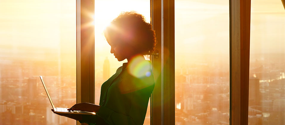 Women on laptop in office at sunset