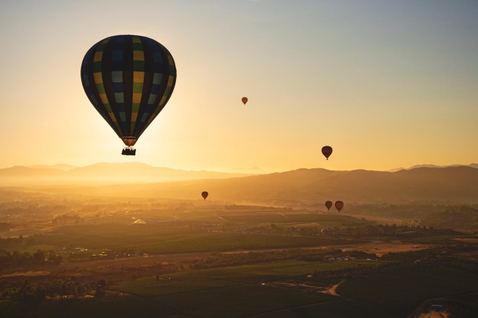 Globos aerostáticos elevándose en el aire en un atardecer en California