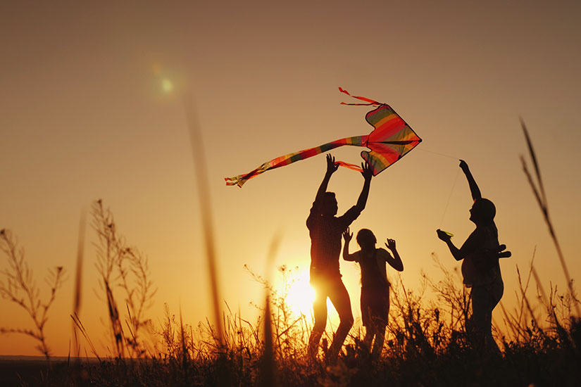 Playing with a kite at sunset