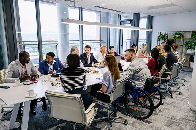 Employees speaking around a table.