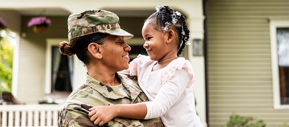 Military service woman hugging a child